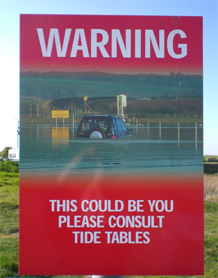 holy island tide warning sign